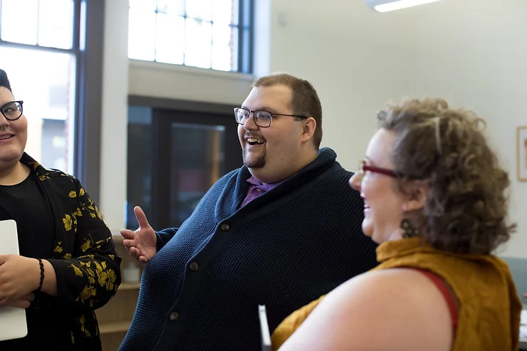 three people are speaking to each other in an informal setting. They just happen to be plus-size people.